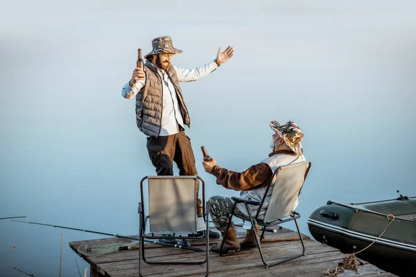 Grandfather with adult son talking on fishing — Stockfoto