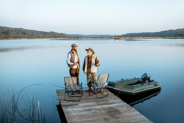 Grandfather with adult son fishing on the lake — 图库照片