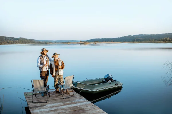 Grandfather with adult son fishing on the lake — 图库照片