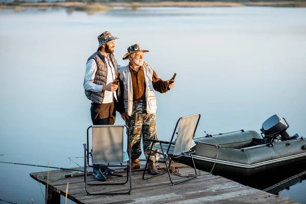 Grandfather with adult son fishing on the lake — Φωτογραφία Αρχείου