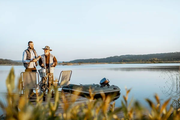 Grandfather with adult son fishing on the lake — Φωτογραφία Αρχείου