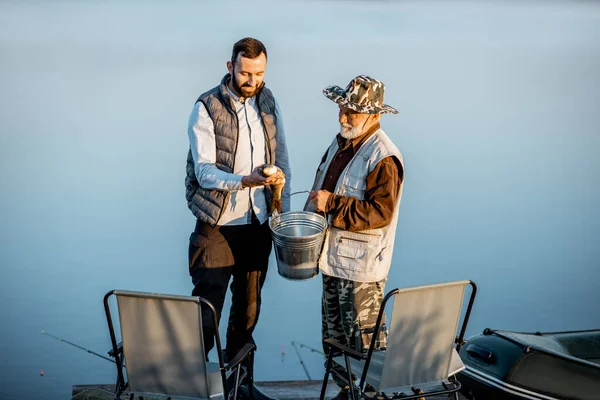 Granfother with son fishing on the lake — Stok fotoğraf