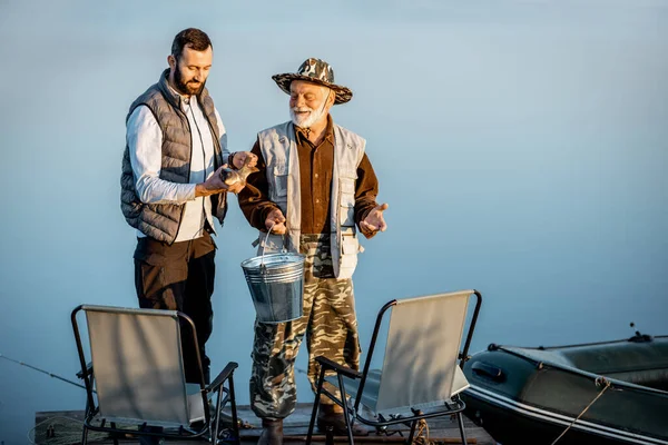 Granfother with son fishing on the lake — Stok fotoğraf