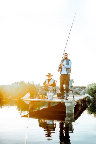 Grandfather with adult son fishing on the lake — Stock Photo, Image