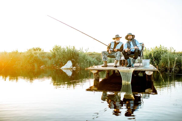 Дідусь з дорослим сином рибалка на озері — стокове фото