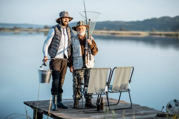 Grandfather with adult son fishing on the lake — 图库照片