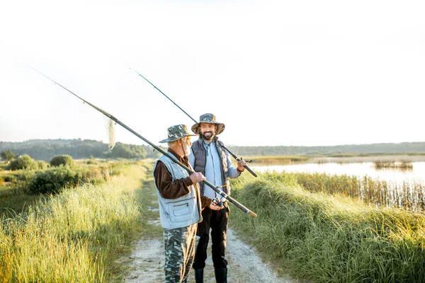 Grandfather with adult son going for fishing — Stockfoto