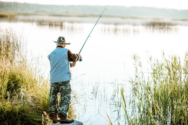 Homem sênior de pesca no lago — Fotografia de Stock