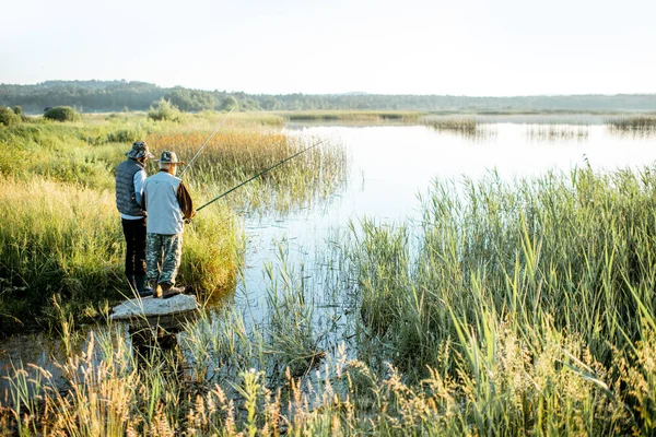 Grandfather with adult son fishing on the lake — Stockfoto