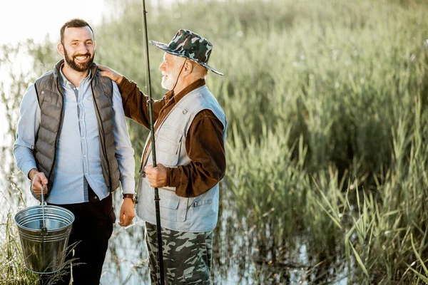 Abuelo con hijo adulto pesca en el lago —  Fotos de Stock