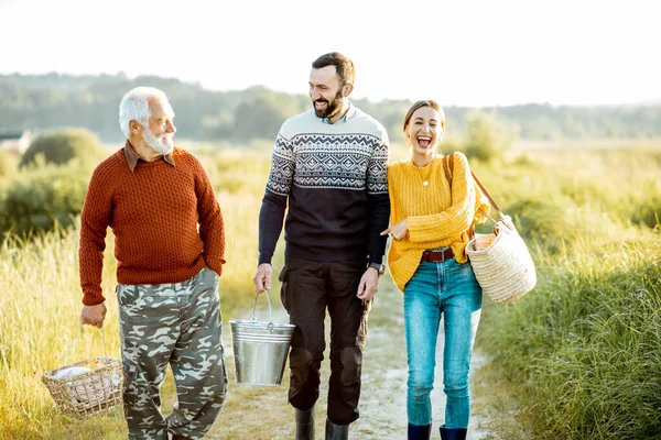 Young man and woman with senior grandfather walking outdoors — Stok fotoğraf