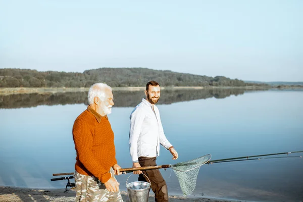 Gandfather with adult son walking for fishing — Φωτογραφία Αρχείου
