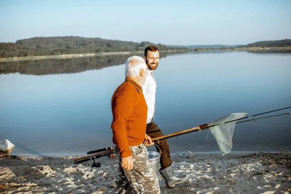 Gandfather avec fils adulte marchant pour la pêche — Photo