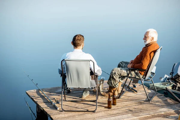 Grandfather with adult son fishing on the lake — 图库照片