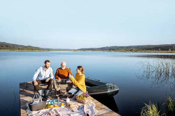 Man and woman with senior grandfather on the picnic outdoors — Stock Photo, Image