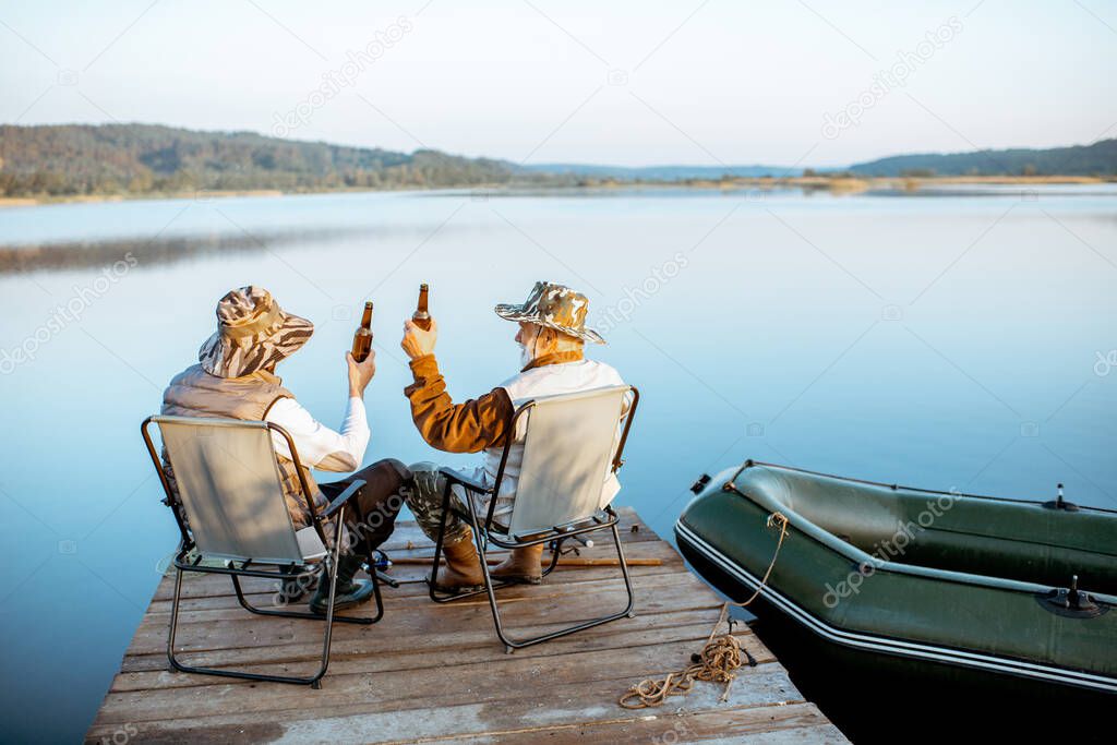 Grandfather with adult son fishing on the lake