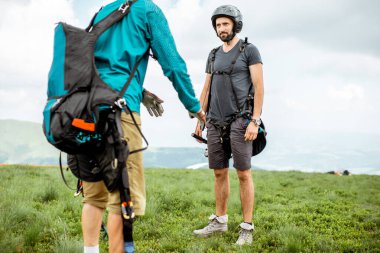 Erkekler paraglider uçuşu için hazırlanıyor.