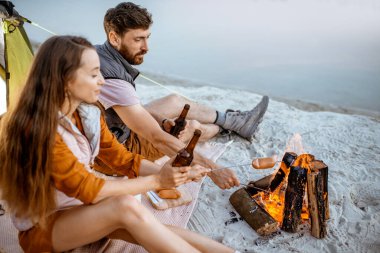 Kumsaldaki kamp alanında bir çift.