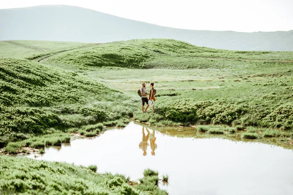Горное озеро и люди путешествующие — стоковое фото