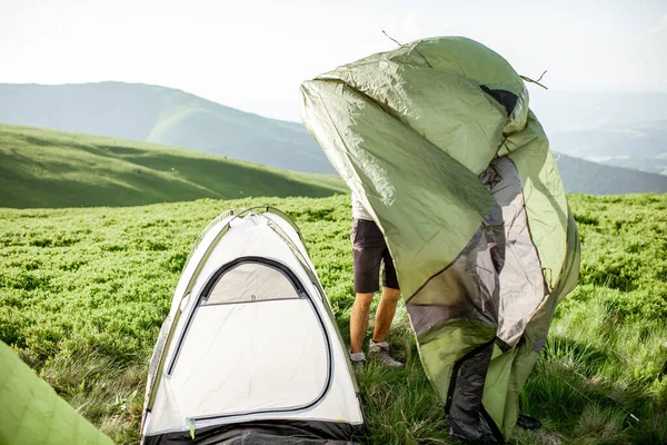 L'uomo che monta la tenda sulle montagne — Foto Stock