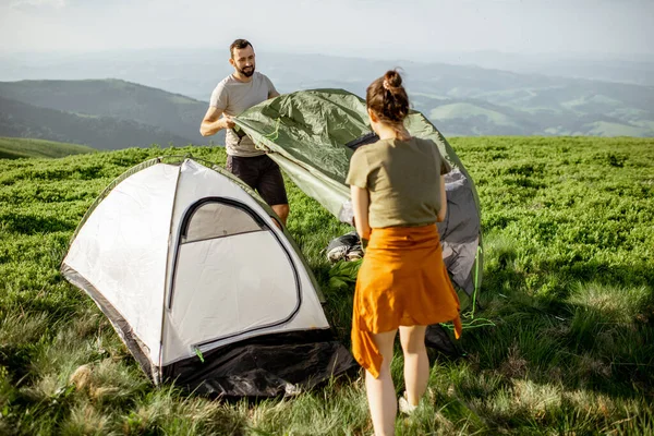 Couple installant la tente dans les montagnes — Photo