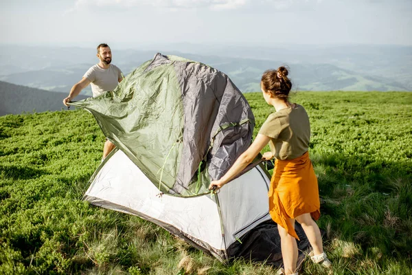 Pareja instalando la tienda en las montañas — Foto de Stock