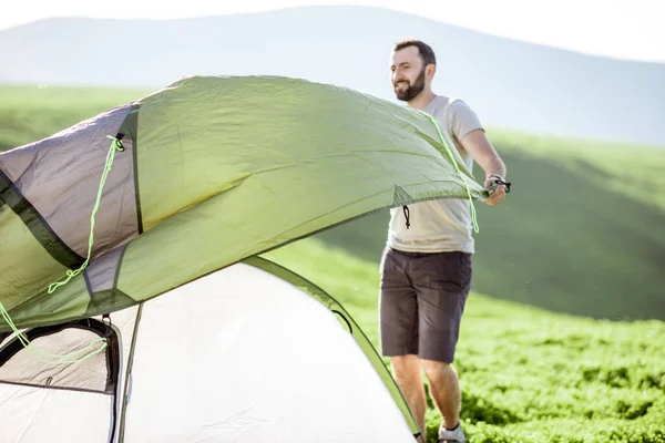 L'uomo che monta la tenda sulle montagne — Foto Stock