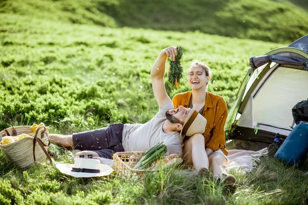 Couple having a picnic near the tent in the mountains — 图库照片