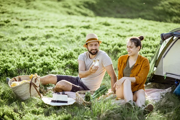 Couple having a picnic near the tent in the mountains — 图库照片