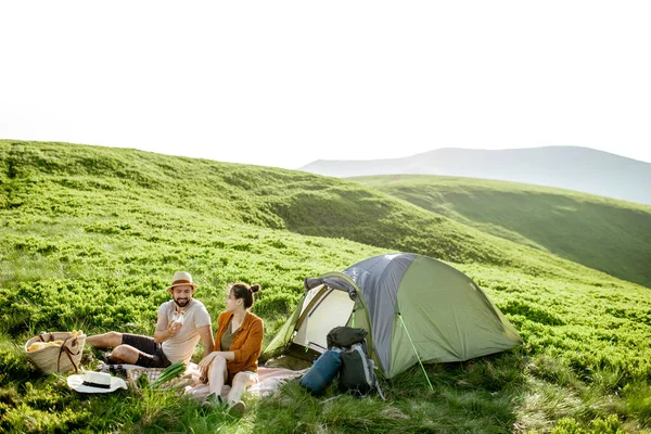 Couple having a picnic near the tent in the mountains — 图库照片