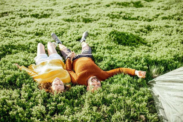 情侣们躺在山中的绿色草地上 — 图库照片