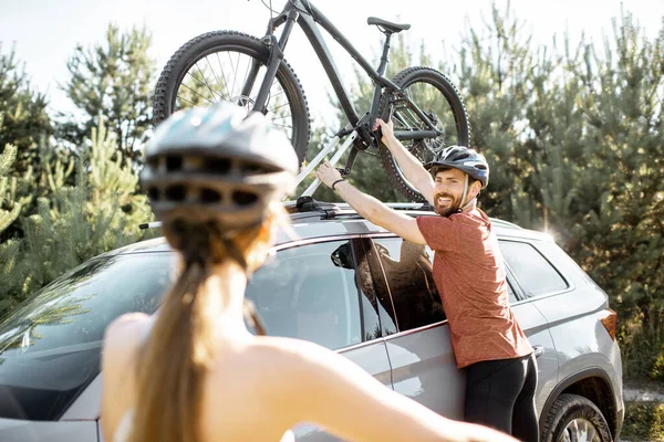 Couple with bicycles and car in the forest — Stock Fotó