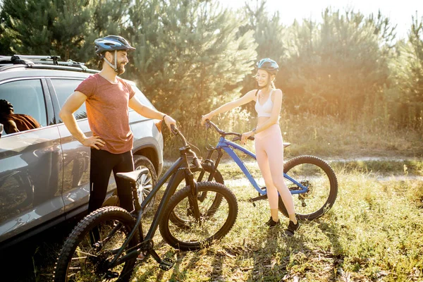 Young couple with bicycles near the car outdoors — Stock Photo, Image