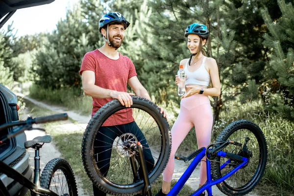 Couple with bicycles near the car in the forest — Stock Photo, Image