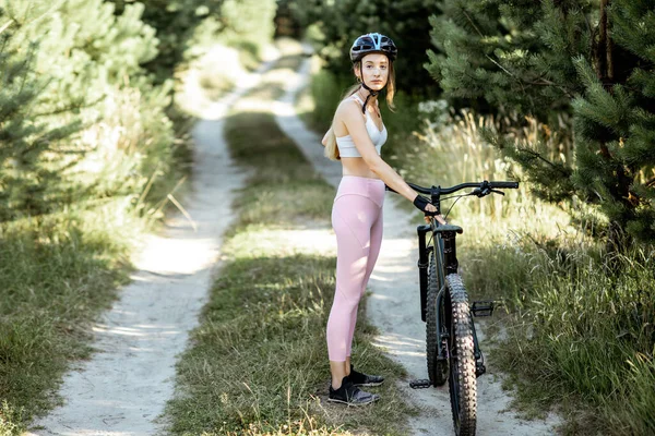 Orman yolunda bisikletli bir kadın. — Stok fotoğraf