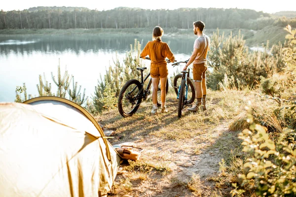山の中を自転車やテントで旅するカップル — ストック写真