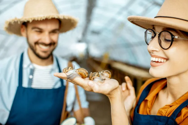 달팽이를 기르기 위해 농장에서 일하는 남녀들 — 스톡 사진