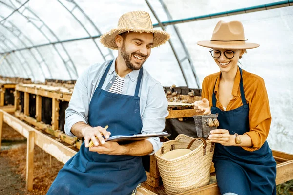 Man och kvinna arbetar på gården för sniglar växer — Stockfoto