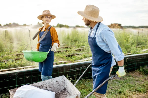 Dos trabajadores en las tierras de cultivo al aire libre — Foto de Stock