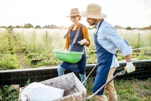 Dos trabajadores en las tierras de cultivo al aire libre —  Fotos de Stock