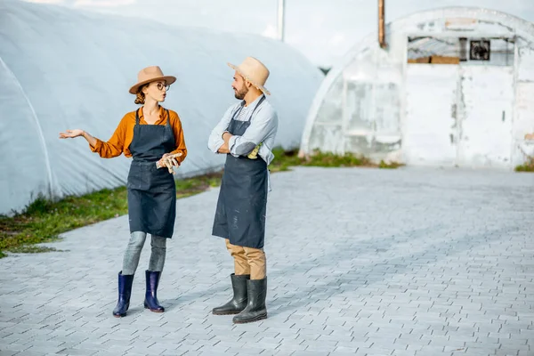 Two farmers on a farm with hothouses outdooors — Stock Photo, Image