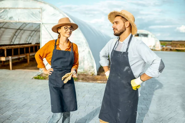 Twee boeren op een boerderij met hothouses outdooors — Stockfoto