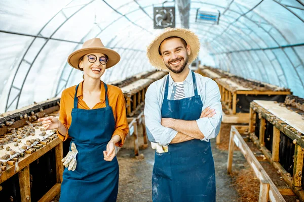 Mężczyzna i kobieta na farmie dla ślimaków rosnących — Zdjęcie stockowe