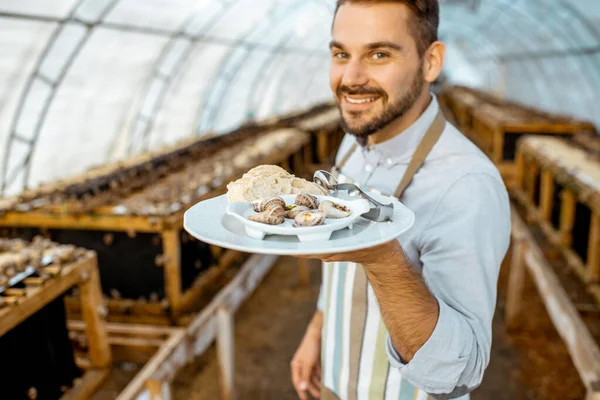 Chef cozinheiro com caracóis cozidos em uma fazenda — Fotografia de Stock