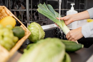 Evde, mutfakta taze sebzeleri yıkıyorum.