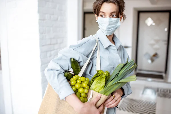 Жінка в медичній масці купує їжу — стокове фото