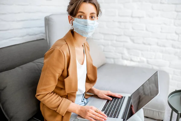 Mulher em máscara médica trabalhando em casa — Fotografia de Stock