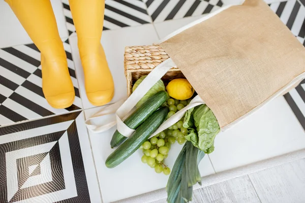 Saco de compras cheio de legumes frescos no chão dentro de casa — Fotografia de Stock