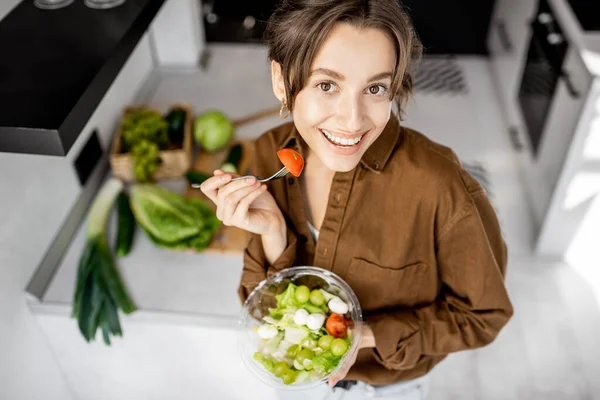 Vrouw met gezonde salade op de keuken — Stockfoto
