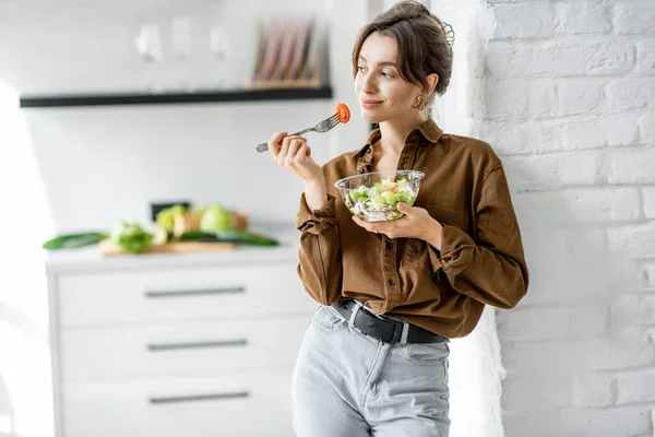 Mujer con ensalada saludable en la cocina — Foto de Stock